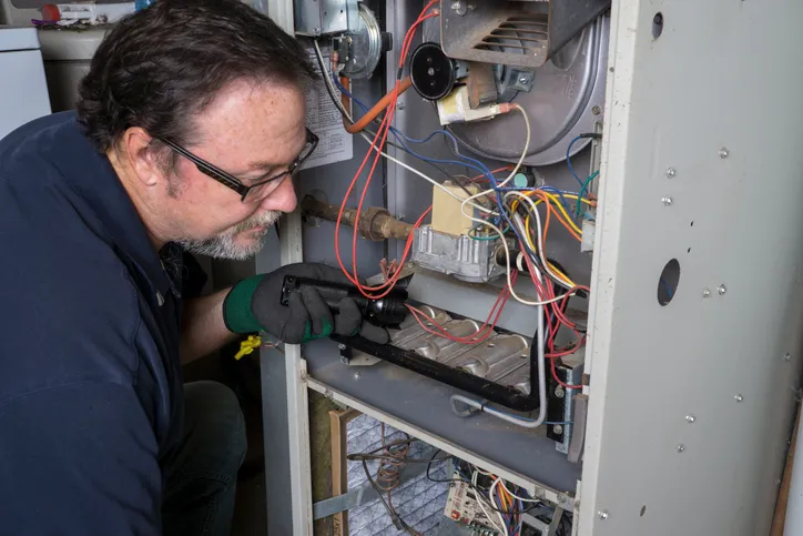 technician servicing a furnace