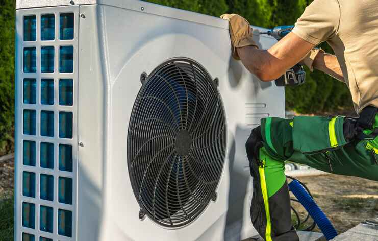 technician servicing a heat pump