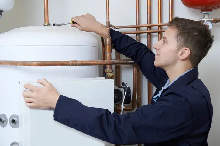 technician servicing a water heater