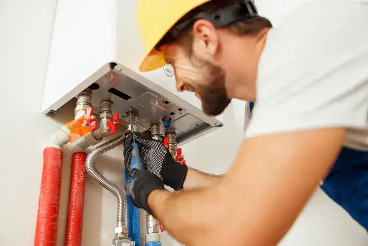 technician servicing a water heater