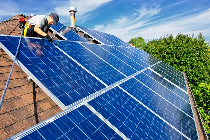 tech working on rooftop solar panel