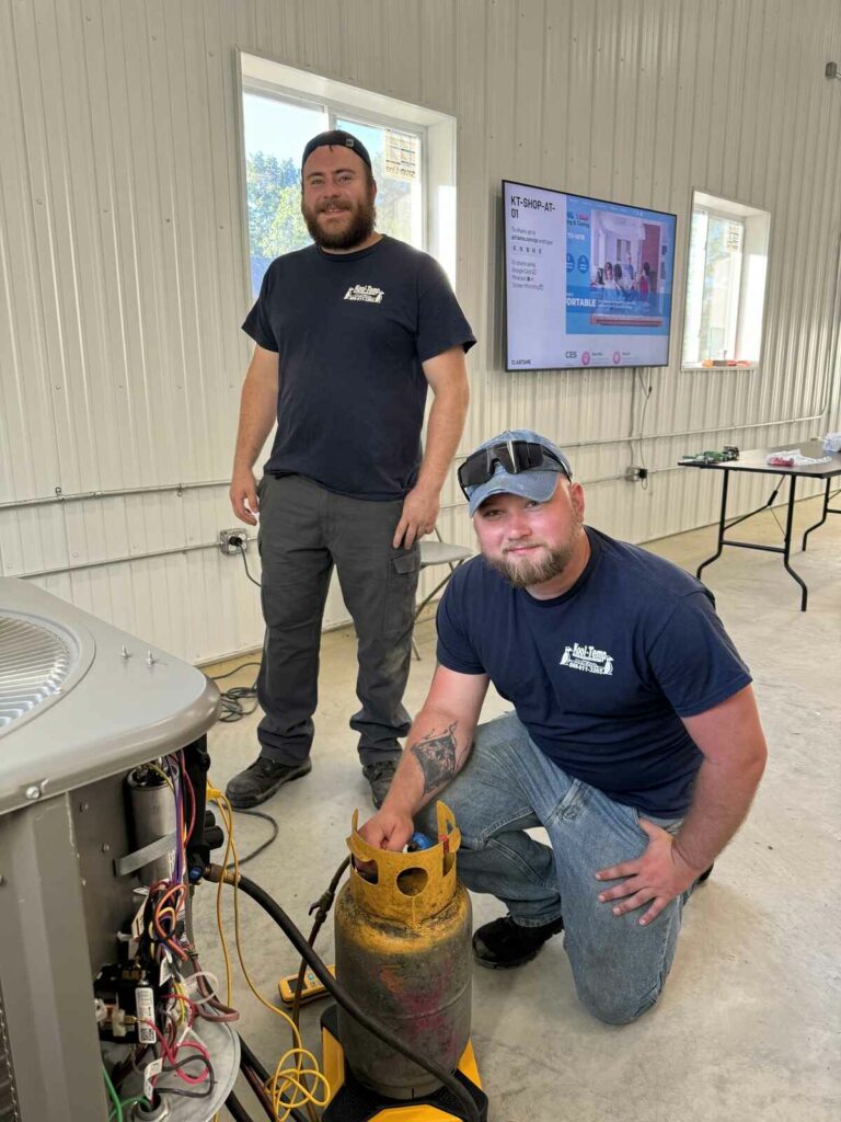 two hvac technicians posing at work